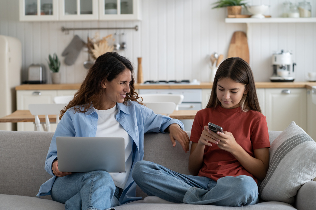 Young Smiling Modern Mother Talking to Child Daughter about Online Safety